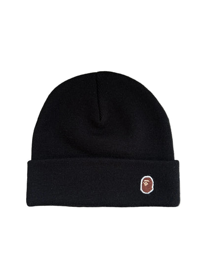 A Bathing Ape BAPE Ape Head One Point Knit Cap in black featuring a rolled brim and an embroidered logo patch