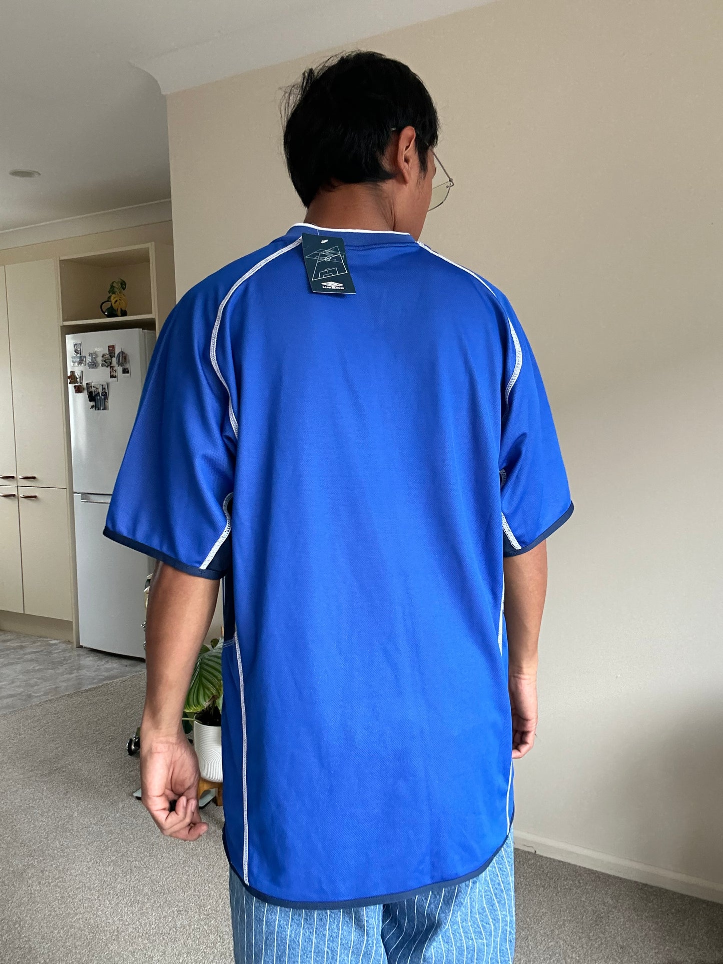 vibrant blue Umbro performance jersey featuring a V-neck design and white piping details XL