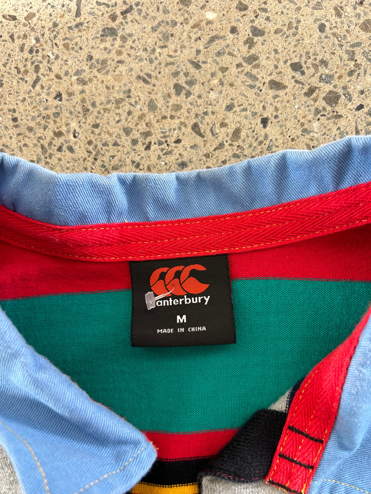 Canterbury of New Zealand short-sleeve rugby jersey features a distinctive multicolored striped design with a large logo