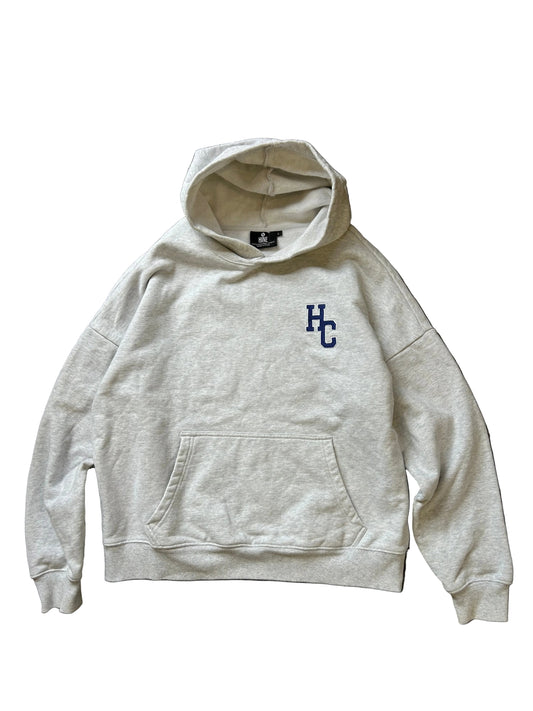 Hine Collection gray hoodie features a prominent navy blue "HC" embroidered logo on the chest