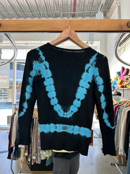 black knit sweater features blue tie-dye accents and floral embroidery with beaded details.