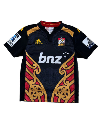 adidas 2014/15 Chiefs Super Rugby home jersey, featuring the prominent black, red, and gold Māori design panels along the sides and the classic bnz sponsor logo across the chest.