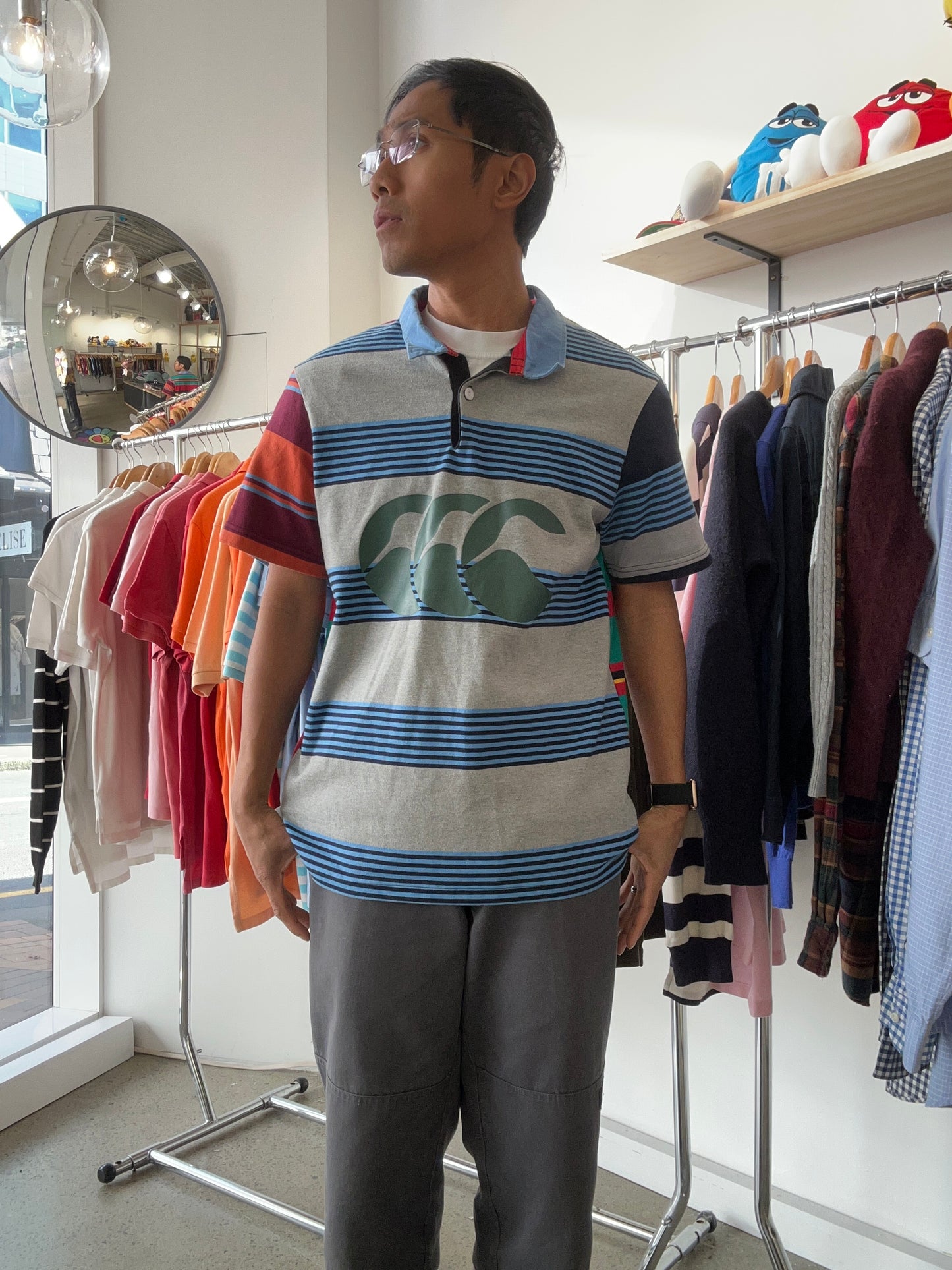 Canterbury of New Zealand short-sleeve rugby jersey features a distinctive multicolored striped design with a large logo